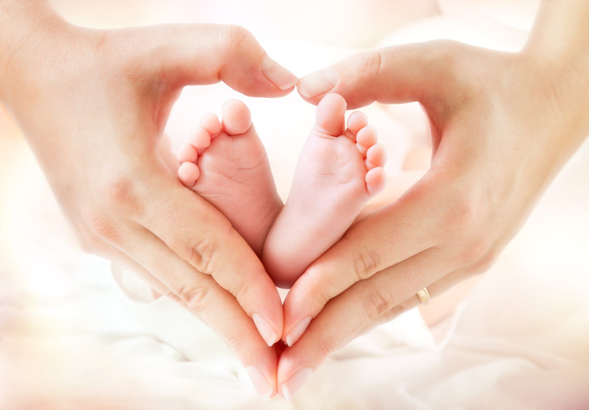 Baby-Füße in Herz geformte Hände